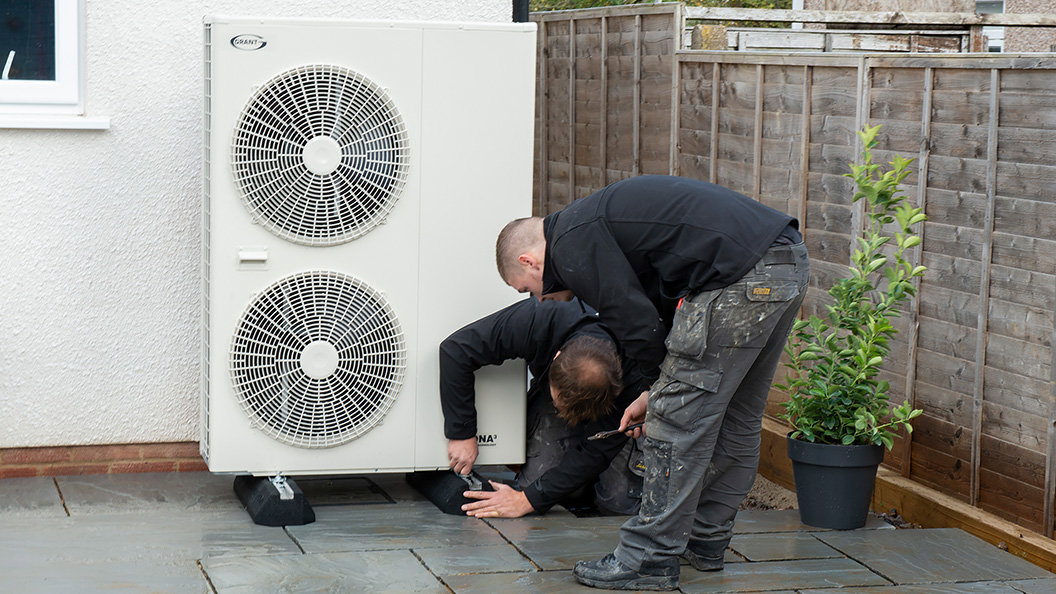 Installers fitting an air source heat pump.jpg