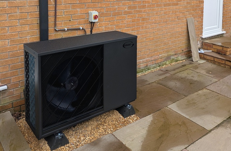 The Aerona 290 heat pump installed on a concrete base with built in soak away, with decorative stone chippings.