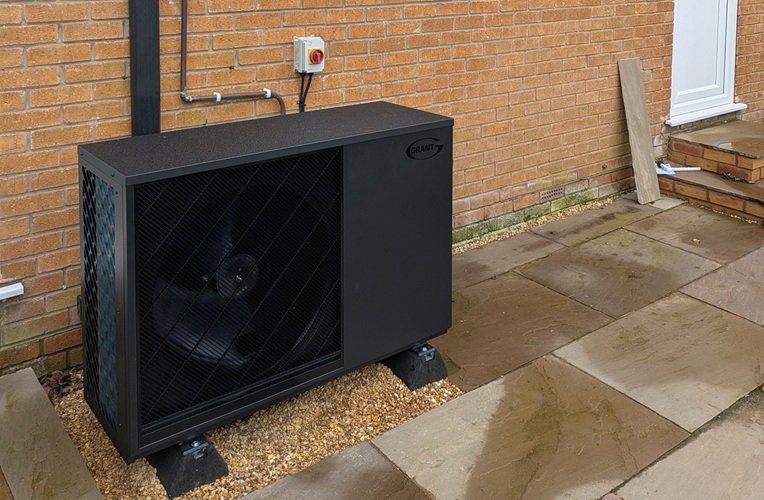 The Aerona 290 heat pump installed on a concrete base with built in soak away, with decorative stone chippings.